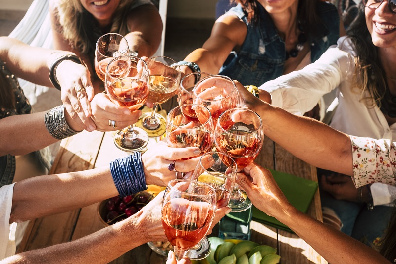 Happy and cheerful group of people females young friends together cheering and toasting celebrating with red wine - happiness and friendship concept during party event for happy women